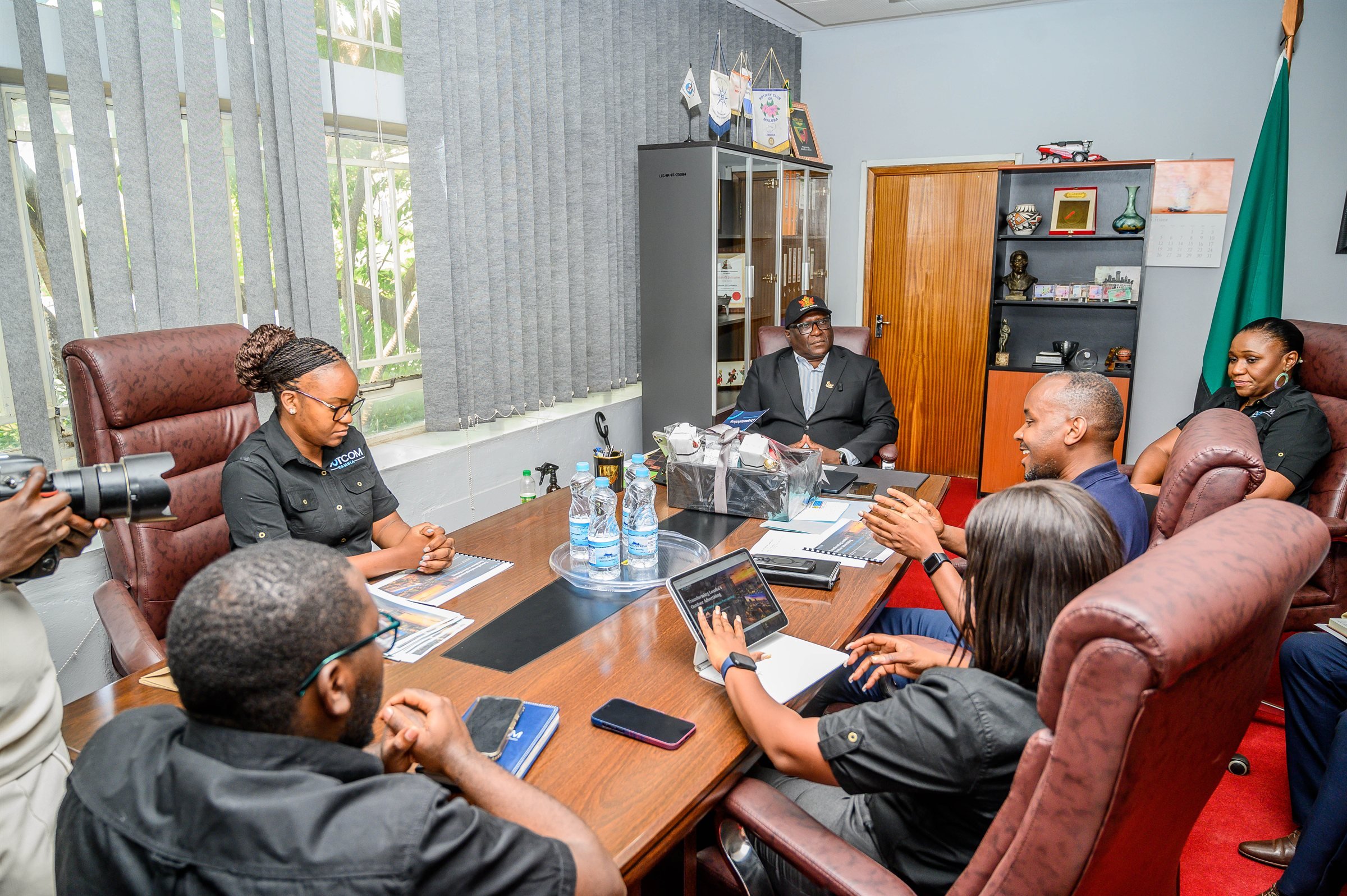 The Dot Com Zambia delegation seated around the Mayor's meeting table