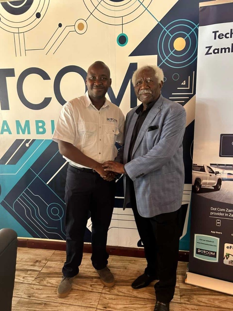 Ambassador Mumba Kapumpa and Mawano Kambeu shaking hands at the Dot Com Zambia offices